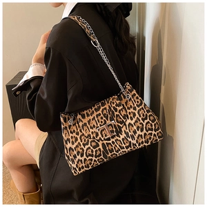 Detail of leopard print handbag featuring a silver chain strap and metal T-shaped buckle
