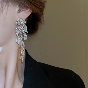 Detail of silver long feather tassel earring with sparkling rhinestones on model