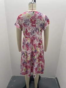 Close-up of pink floral dress featuring multi-layered ruffled hem and fluid fabric detail