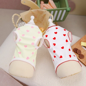 Detail of dog vests with heart prints, wavy edges and breathable fabric on wooden stands
