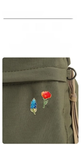 Detailed view of exquisite enamel lily of the valley and poppy flower brooches with gold edges