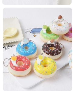 Gros plan de porte-clés donuts colorés en mousse PU avec pépites et fruits sur un plateau