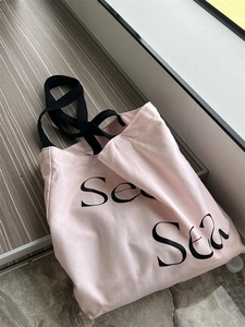 Detail of pink canvas tote bag showing thick texture and black letter Sea print