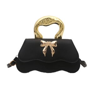 Chic black PU leather shoulder bag with gold wave handle and bow clasp on white background