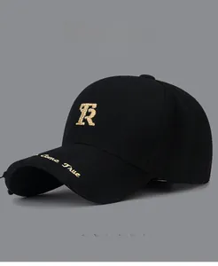 Close-up of golden R embroidery and distressed ripped brim on black cotton baseball cap