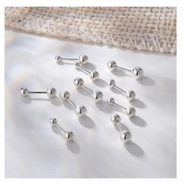 Macro shot of S925 sterling silver screw back stud earrings in multiple sizes on white fabric