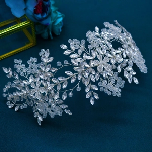 Exquisite detail of silver bridal headband with crystal flowers on blue background