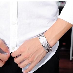 Detail of silver stainless steel chain bracelet with engraved rectangle plaque on wrist