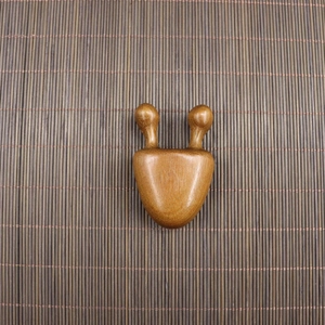 Macro detail of sandalwood massage tool with smooth round tips and natural wood grain