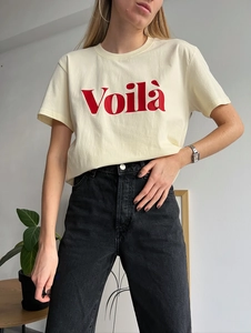 Eng anliegendes cremefarbenes T-Shirt mit rotem Voilà-Aufdruck auf schlichtem Grund