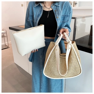 Detail of handwoven straw tote bag paired with white PU clutch in a cafe setting