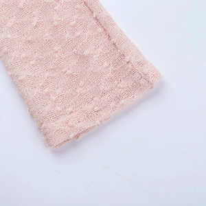 Détail d'une robe en maille rose clair avec pois 3D et tissu texturé respirant