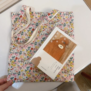 Floral print canvas tote bag with a minimalist aesthetic lying flat on a white surface