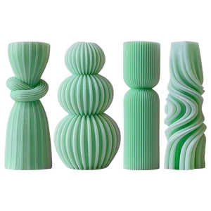 Set of four striped cylindrical green scented candles on a clean white background