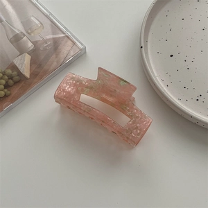 Detail einer großen hohlen Haarklammer mit rosa Marmor-Struktur aus Acetat-Material
