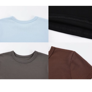 Detailed view of neckline stitching and knit texture in multiple solid colors