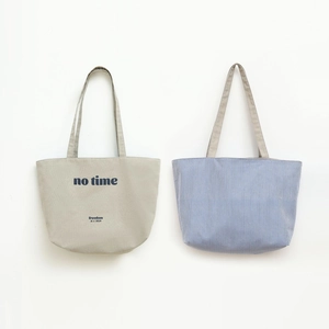 Detail of dual-style canvas tote bags showing letter print and nautical blue stripes