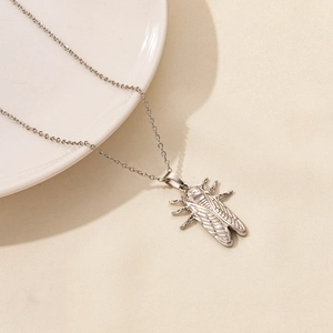 Detailed close-up of a silver stainless steel cicada pendant on a delicate link chain