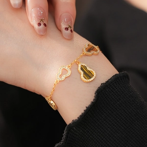 Close-up of a gold gourd bracelet with tiger eye stone and white zircon on a wrist