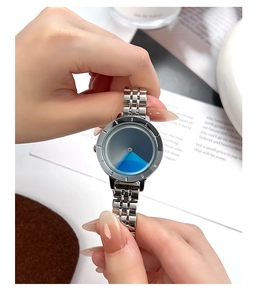 Close-up of a minimalist silver steel watch featuring a gradient blue-grey dial design