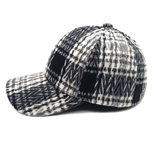 Detailed view of the thick black and white plaid wool texture on the baseball cap