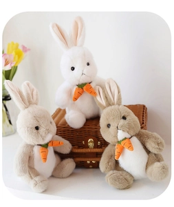 Three plush rabbits in white and light brown holding carrots on a woven basket