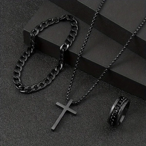 Close-up of matte black cross necklace, Cuban link bracelet and embossed chain ring set