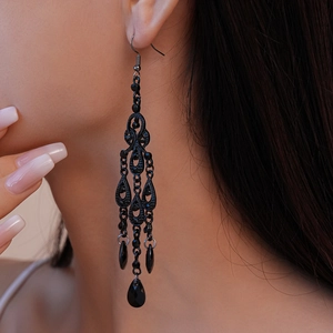 Dark gothic hollow water drop tassel earrings with black rhinestones on a model