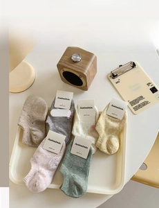 Detailed close-up of six-color combed cotton low-cut socks in a cozy home setting