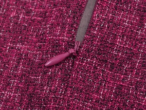 Close-up of invisible zipper on elegant burgundy tweed fabric with woven texture