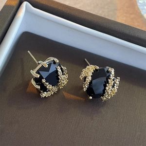 Macro shot of gold plated wheat ear earrings with square black gemstone inlay