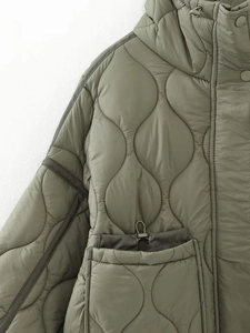 Macro detail of wave quilted olive green puffer jacket with drawstring pocket
