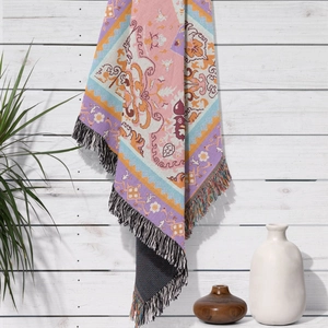 Detail of bohemian woven throw blanket with colorful ethnic patterns and long fringes