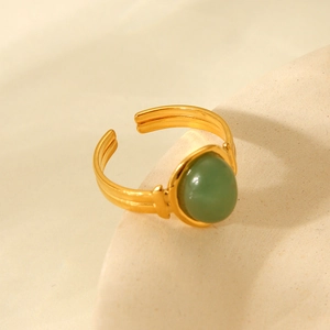 Macro shot of 18K gold plated oval green gemstone ring with grooved texture band