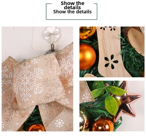 Detail of Christmas wreath with linen bow, gold baubles, and wooden star ornaments