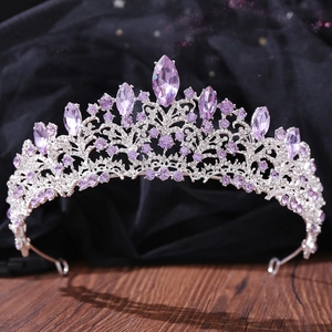Close-up of luxury bridal crown with purple crystals and sparkling rhinestones on velvet