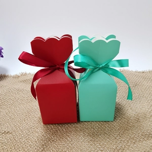 Red and mint green striped candy boxes with wavy edges and ribbon bows for weddings