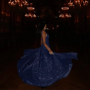 Détail de la robe de soirée bleu marine à paillettes avec dos nu et ourlet fluide au sol