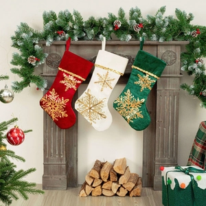 Close-up of velvet Christmas stockings with golden snowflake embroidery on a fireplace