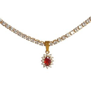 Close-up of vintage 18k gold plated necklace with oval red zircon and sparkling tennis chain