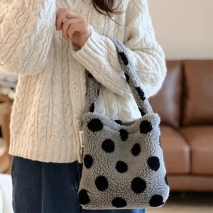 Détail du mini sac cabas en laine d'agneau à pois noirs avec une texture moelleuse