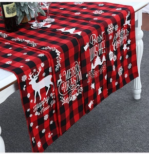 Macro-detail van de rood-zwarte geruite kersttafelloper met feestelijke elandmotieven
