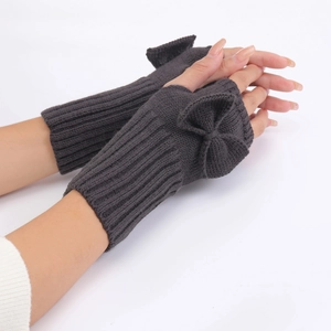 Detail of dark grey knit fingerless gloves with bow accent showing fine texture