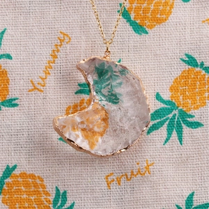 Close-up of crescent moon pendant necklace with clear ice-cracked resin and gold trim