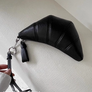 Détail de la pochette à lunettes en cuir noir avec dragonne et crochet métallique