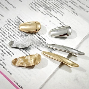 Minimalist metallic hairpins in gold and silver finish on vintage newspaper background
