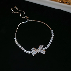 Detail of silver bow bracelet featuring sparkling zircon inlay and adjustable slide clasp