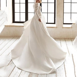 Elegante abito da sposa in raso bianco con maniche lunghe, strascico e dettaglio sulla schiena