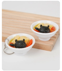 Dettaglio macro di un portachiavi miniatura zuppa di tartaruga e pollo da 6,5 cm con bacche di goji