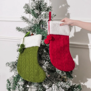 Detail of knitted Christmas stockings in red and green with white plush cuffs and pom-poms
